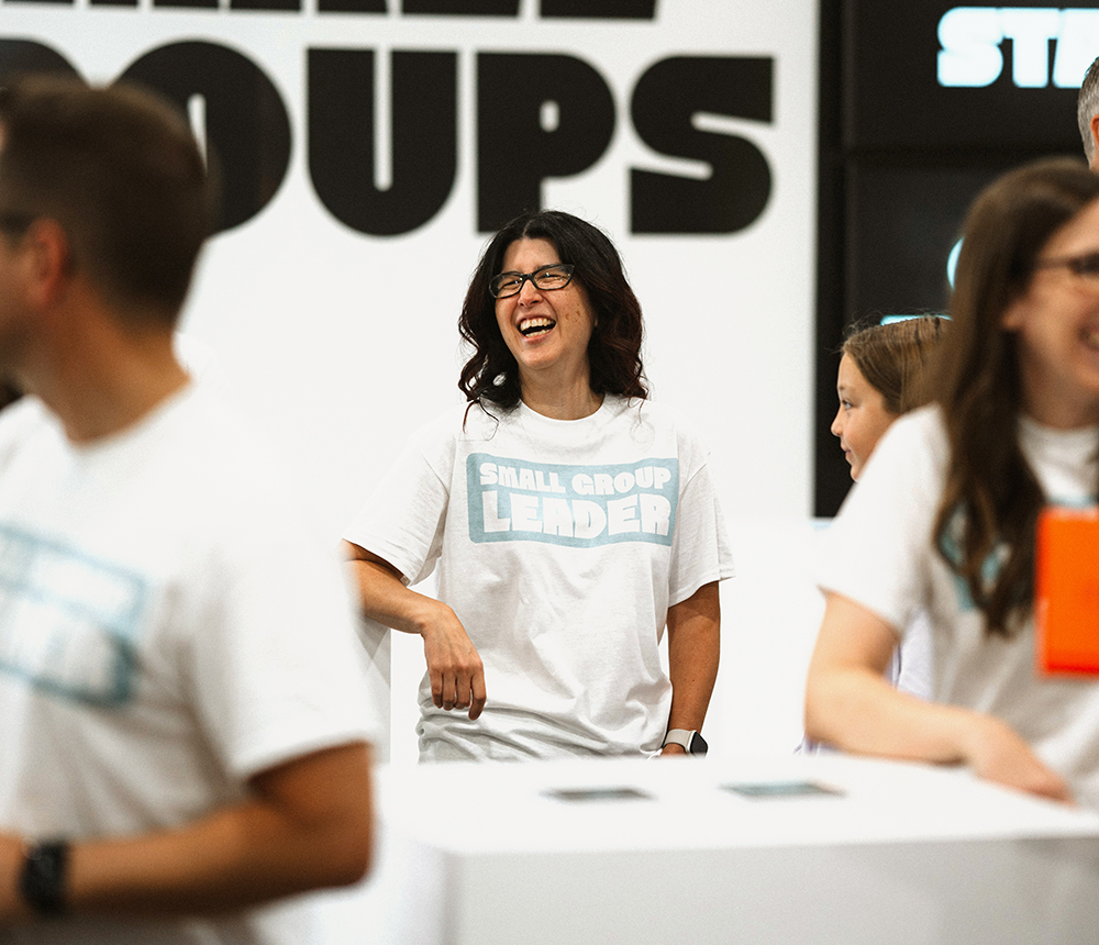 woman laughing with white shirt that says small group leader