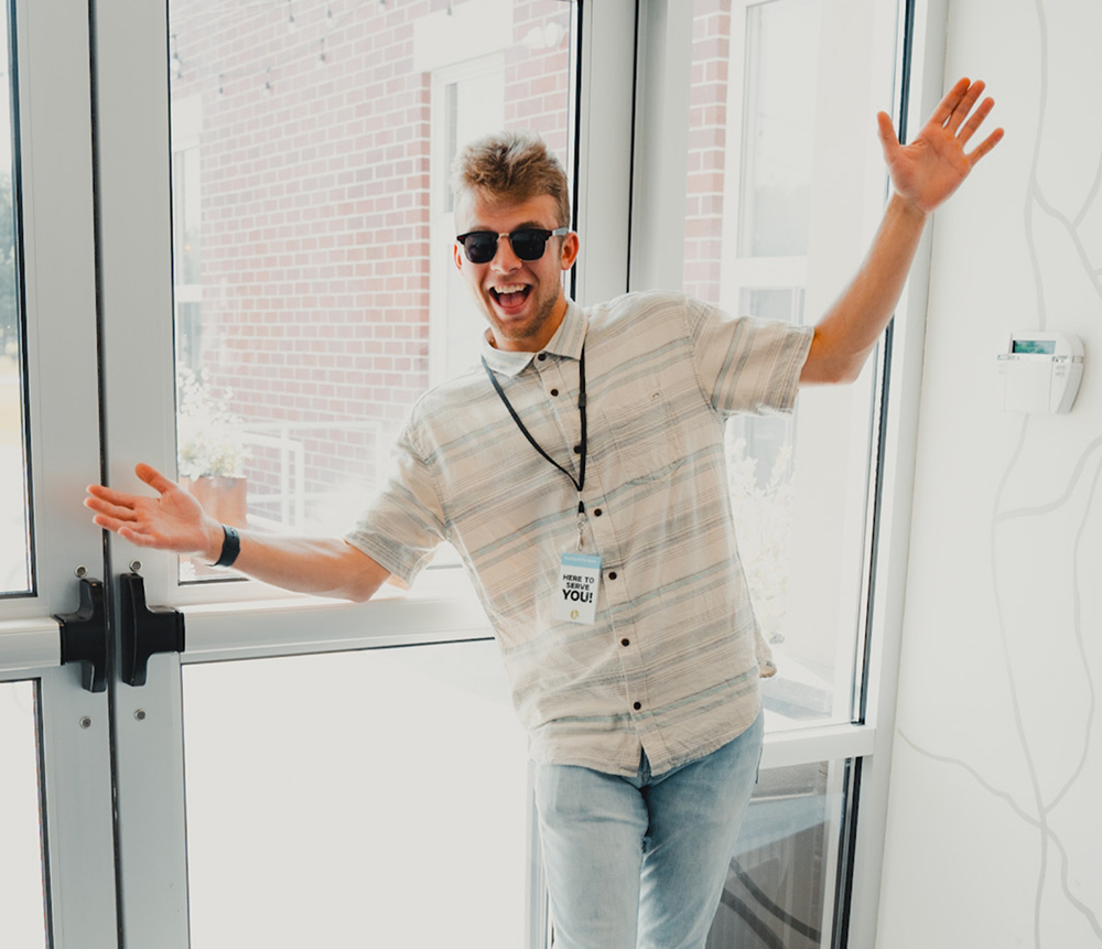 man smiling with arms spread out